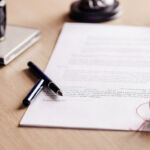 Form N-PORT Notary pen lying on testament. Notary public working accesories