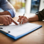 Cropped shot of a man and woman completing paperwork together at a desk