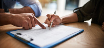 Cropped shot of a man and woman completing paperwork together at a desk