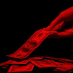 Hand taking dollar from pile illuminated by red light, bloody money crime reward