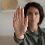 Worried concerned young woman showing palm, making hand stop denial gesture, expressing prohibition, refusal, fighting for equal rights against domestic violence, abuse, discrimination, bullying