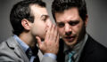 image of a young professional whispering to another