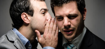 image of a young professional whispering to another