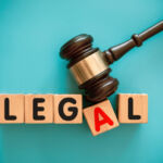 Gavel and toy block with "LEGAL" on blue background.