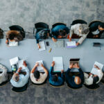 Top view of diverse business group in office meeting, collaborating and discussing around a large table.