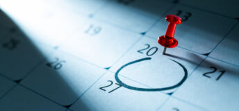 Red push pin on calendar with circle mark on 20