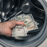 Your thoughts sought on FinCEN IA AML rule American dollars being put into the washing machine, Concept, Money laundering, Illegal business proceeds, Dark business, Black market, Bundle of 100 dollar bills