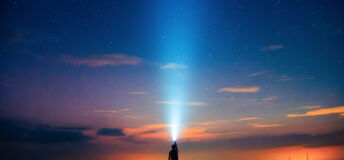 A person holding a flashlight under the starry sky