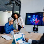 Coworkers collaborating on AI project during business meeting in office