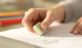 Close up of woman hands using rubber erasing pencil drawing on a desk at home