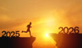 New Year 2026, Inspiration and progress towards new success. Silhouettes of human jumping over cliff towards finish line with text new year 2026 on sunset beautiful