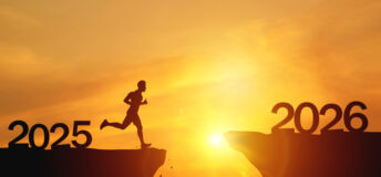 New Year 2026, Inspiration and progress towards new success. Silhouettes of human jumping over cliff towards finish line with text new year 2026 on sunset beautiful