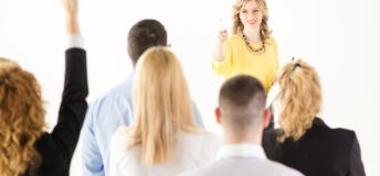 Friendly business woman explaining plan of work and answering the question. The team is listening and asking the questions.