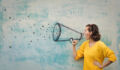 Young woman holding an imaginary megaphone and shouting into it