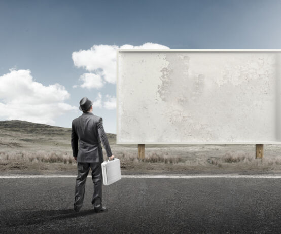 SEC releases two new marketing FAQs A business man standing and staring at a blank billboard advertisement.