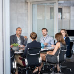 How DOE would be affected by a federal government shutdown Business people sitting in boardroom and working together at new strategy plan. Group of leader and businesspeople in a meeting at office. Senior executive with his team working in a conference room.
