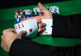 Man with ace up his sleeve, cheating at poker.
