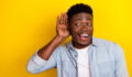Photo of positive guy interested incredible discount message look empty space hear isolated vibrant color background.