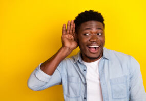 Photo of positive guy interested incredible discount message look empty space hear isolated vibrant color background.