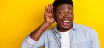 Photo of positive guy interested incredible discount message look empty space hear isolated vibrant color background.