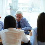 Business people having meeting, elderly CEO leading the discussion