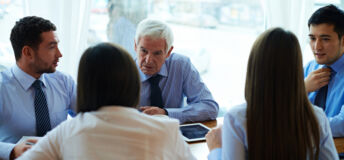 Business people having meeting, elderly CEO leading the discussion