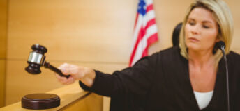 Judge about to bang gavel on sounding block in the court room