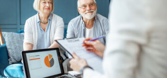 Happy senior couple during the meeting with agent or financial consultant, signing some agreement in the comfortable office