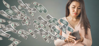 unhappy and poor Asian woman holding purse having problem with money flying away, over spending concept background