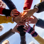A group of women over 50 come together in a powerful display of teamwork and camaraderie during a walking netball training session. With hands stacked in the center, they celebrate friendship, fitness, and shared determination. Videos are available similar to this scenario.