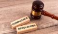 Top view of gavel and wood block with text compliance and regulations