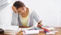 Head and shoulders shot of a college student reading through her class work