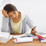 Head and shoulders shot of a college student reading through her class work