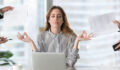 Calm female executive meditating taking break at work for mental balance, mindful businesswoman feeling relief and no stress doing yoga at work ignoring avoiding stressful job and paperwork in office