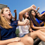 Sports fans cheering and booing opposing team in stadium
