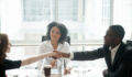 Smiling african businessman handshaking greeting caucasian businesswoman at group meeting negotiation, black satisfied entrepreneur welcoming partner shaking hand in lawyers office, respect concept