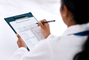Cropped shot of an unrecognizable female doctor writing on a clipboard while working in her office