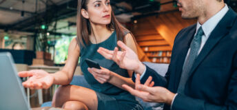 Businessman and business woman have lively discussion in modern office