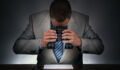 Businessman studying a contract to sign closely with binoculars concept for checking the small print