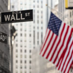 SEC release: Consolidated Audit Trail and other audit trails and data sources Wall street sign in New York City with American flags and New York Stock Exchange in background.