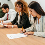 Group of people having a business meeting at the office. They are signing a business contract.