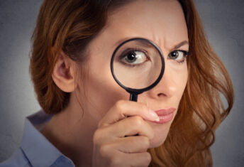 Part 1 of a series: Private fund exam probes valuation Headshot woman investigator looking through magnifying glass