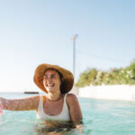 Photo of a young woman enjoying her vacation and cooling of on a hot summer day in a swimming pool