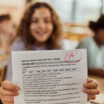 Former SEC staffer pockets $200k in crypto Close up of a schoolgirl showing her A grade on a test at elementary school.