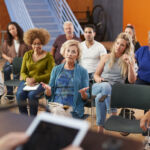 Woman Speaking At Group Neighborhood Meeting In Community Center