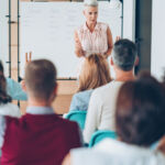 Teacher talking to the class in a board room