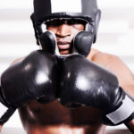 Valuations: conflicts (and interest) An african american boxer wearing protective gear standing in the ring