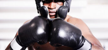 An african american boxer wearing protective gear standing in the ring