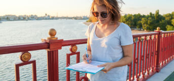 Business woman working outdoor, female with paper document on clipboard, social worker interviewing people on the street