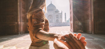 Follow me to the Taj Mahal, India. Female tourist leading boyfriend to there magnificent famous Mausoleum in Agra. People travel concept